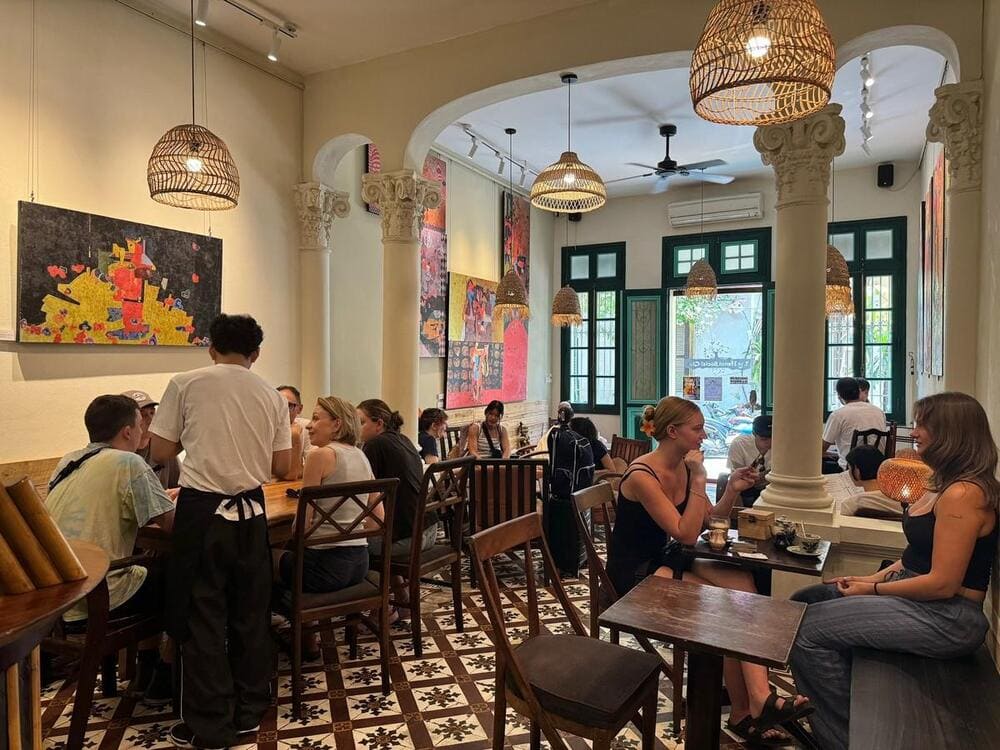 The bohemian interior of The Hanoi Social Club features vintage mismatched furniture, local artwork on walls, creating a cozy creative atmosphere (Source: The Hanoi Social Club)
